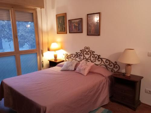 - une chambre avec un lit avec des draps roses et une fenêtre dans l'établissement casa miglio, à Marina di Pietrasanta