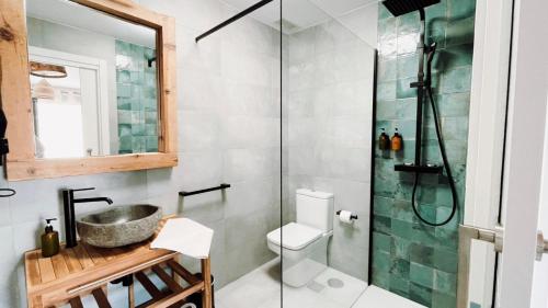 代米耶尔Apartamentos Los Flamencos的带淋浴、卫生间和盥洗盆的浴室
