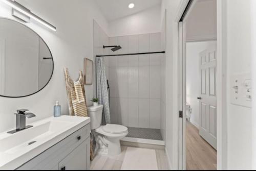 uma casa de banho com um WC, um lavatório e um espelho. em Adam's Retreat - 5 min from Beach - 2bed/2bath em Cape Canaveral