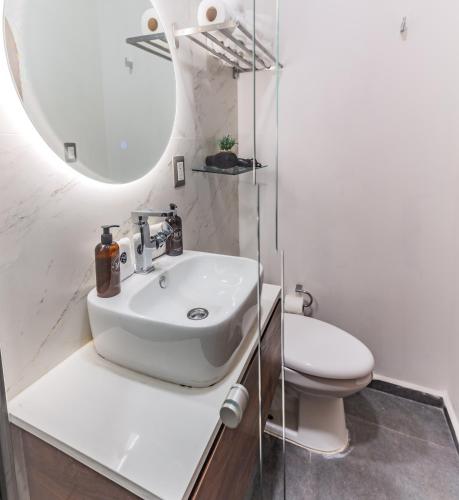 a white bathroom with a sink and a toilet at Casa Castillo in Mexico City