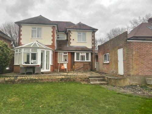 uma casa com um relvado em frente em Lovely Detached house in lovely location em West Drayton