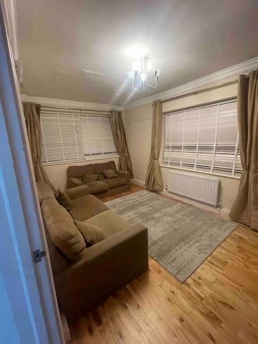 a living room with a couch and a window at Lovely Detached house in lovely location in West Drayton