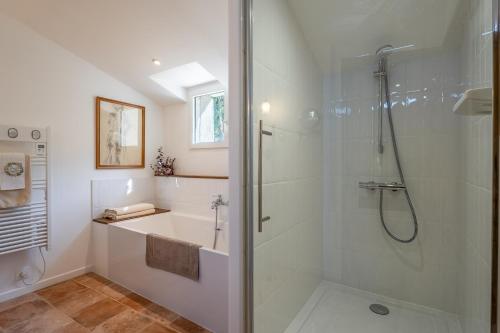 a white bathroom with a shower and a sink at Villa Vauvert in Saignon