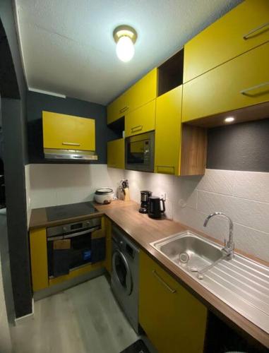 una cocina con armarios amarillos y fregadero en Quiet Place, en Cayenne