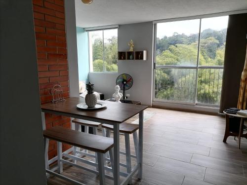cocina con mesa y ventana grande en Bonito y central apartamento, en Pereira