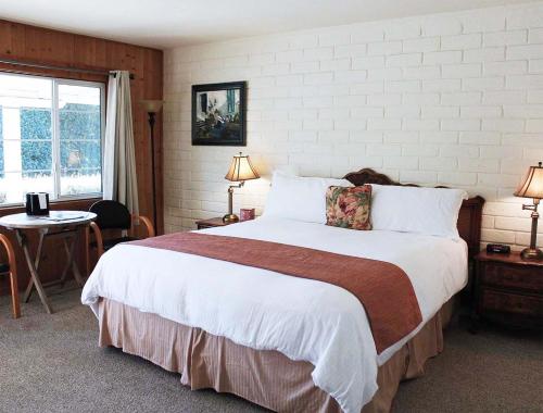 a bedroom with a large bed and a table at Back Bay Inn in San Luis Obispo