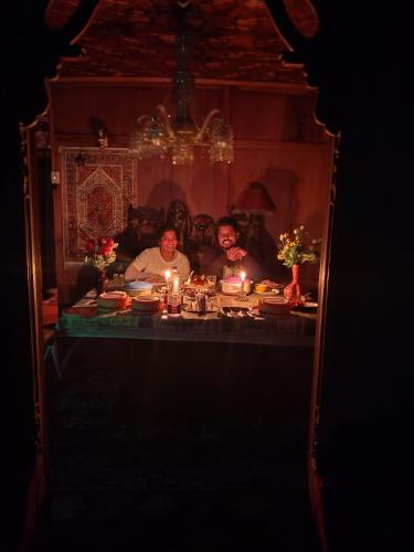 a group of three people sitting at a table with candles at Honolulu Group Of Houseboats in Srinagar