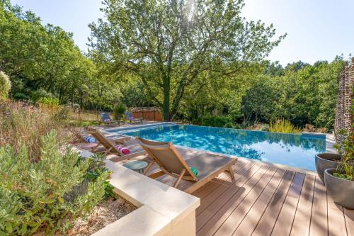 a backyard with a swimming pool and a wooden deck at Villa Vauvert in Saignon