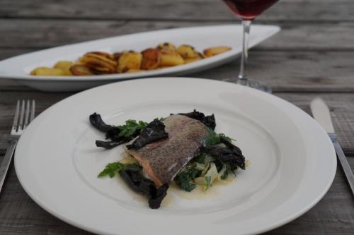 a plate of food on a table with a glass of wine at Waldhotel Schinkenwirt in Olsberg