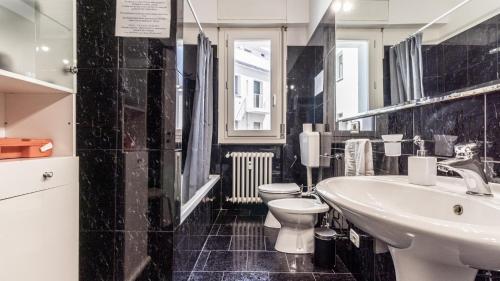 a black and white bathroom with a toilet and a sink at Grand Central - Affitti Brevi Italia in Modena