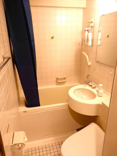 a small bathroom with a sink and a toilet at Shinjuku Harusame Apartment -Twin room- in Tokyo