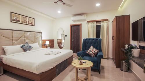 a hotel room with a bed and a blue chair at Radhe Suites in Hyderabad