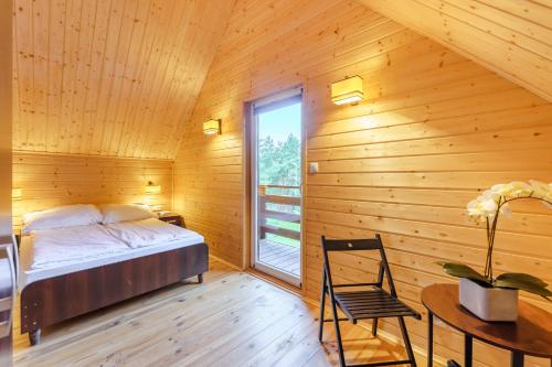 a bedroom with a bed and a desk and a window at Nadmorska House in Grzybowo