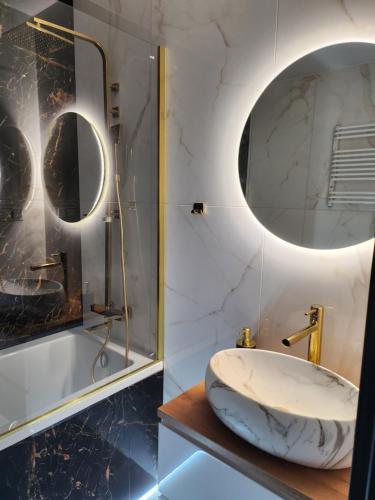 a bathroom with a marble sink and a tub at Apartament z widokiem in Zgorzelec