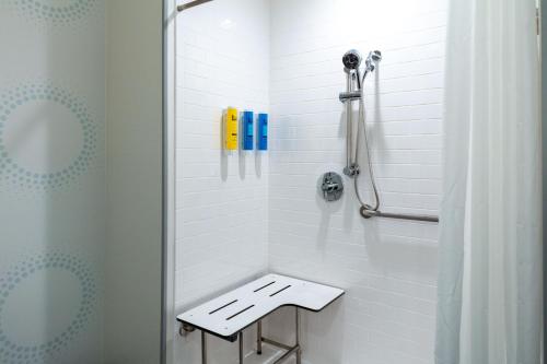 a bathroom with a shower with a bench in it at Tru By Hilton St Louis Downtown Mo in Saint Louis