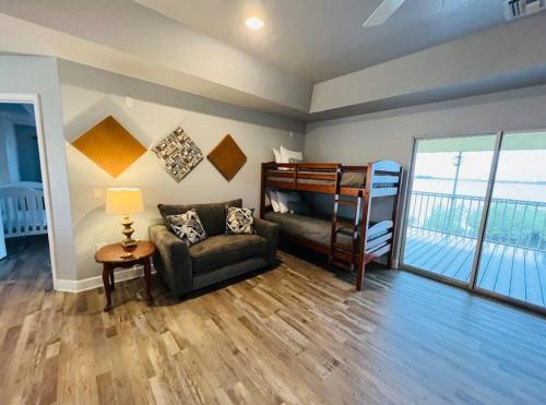 a living room with a bunk bed and a couch at Tropical Riverfront Paradise - Gorgeous Sunset Views in Merritt Island