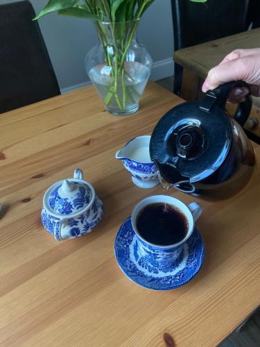 a tea pot on a table with a cup of coffee at The Old Postie Bed & Breakfast in Annesley