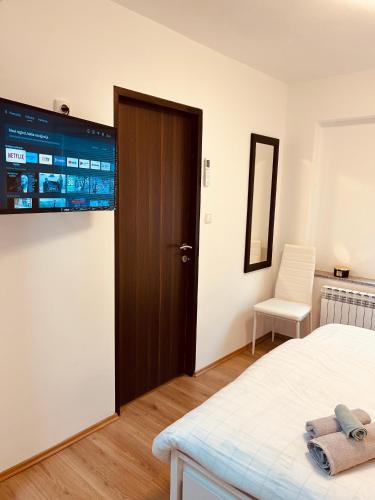 a bedroom with a bed and a door and a chair at Apartment In Time in Sesvete