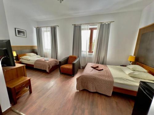 a hotel room with two beds and a chair at Willa Brancon in Babimost