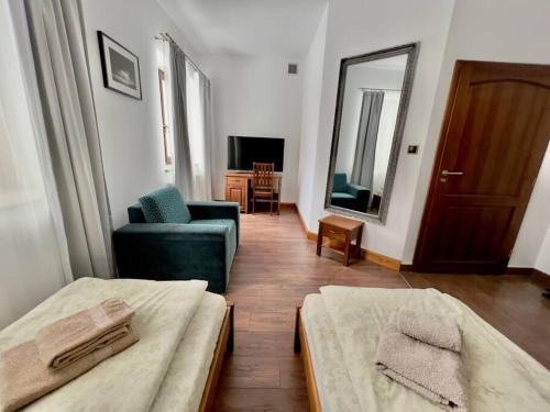 a room with two beds and a chair and a mirror at Willa Brancon in Babimost