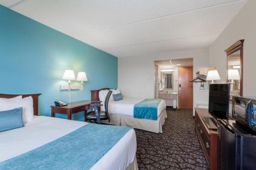 a hotel room with two beds and a flat screen tv at Days Inn Hershey in Hershey