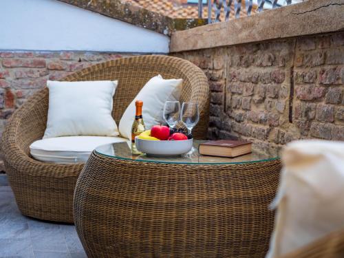 - une table avec un bol de fruits et une bouteille de vin dans l'établissement Blossoms of Siena, à Sienne