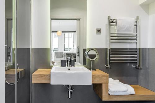 a bathroom with a white sink and a shower at Home Suite Home Gran Via in Madrid