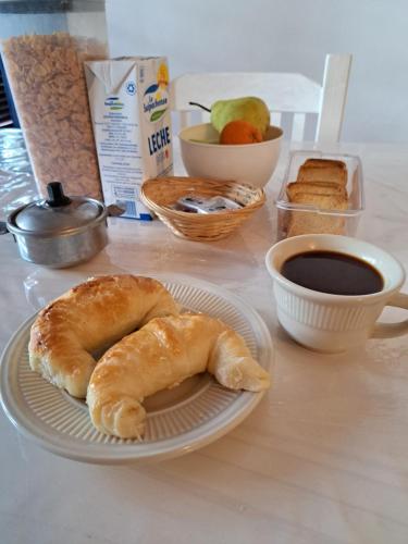 Una mesa con un plato de pasteles y una taza de café. en Bed & Breakfast Delta Inn - Río Tigre, en Tigre