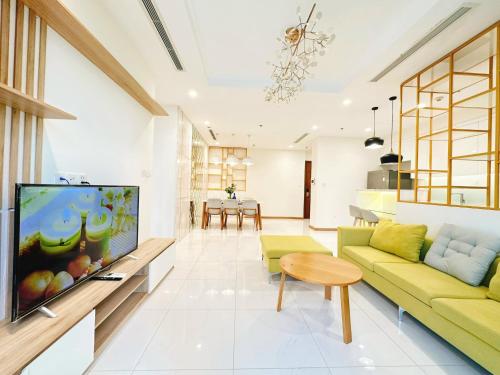 uma sala de estar com um sofá amarelo e uma televisão de ecrã plano em Luxury Vinhomes Central Park (Cozy Apartment) em Ho Chi Minh