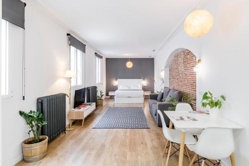 - un salon avec un canapé et une table dans l'établissement Home Suite Home Gran Via, à Madrid