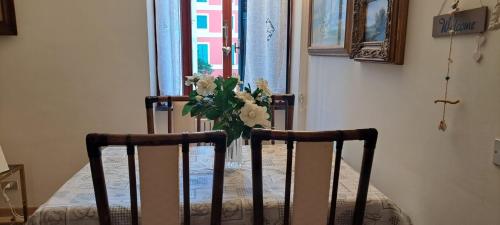 een vaas met bloemen op een stoel bij Casa Giordano in centro e sul mare pos posto auto in Santa Margherita Ligure