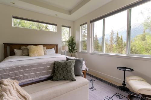 een slaapkamer met een bed, een bank en ramen bij Cozy Private Hot Tub, Luxe Views! Shiloh&harmony in Eagle River