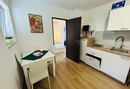 a kitchen with a table and a small kitchen with a sink at Apartment In Time in Sesvete