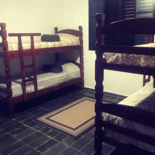 Zimmer mit 2 Etagenbetten und einem Teppich auf dem Boden in der Unterkunft Jardim Secreto in Serra Negra