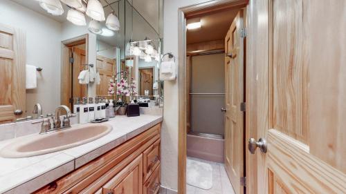 ein Bad mit einem Waschbecken und einem Spiegel in der Unterkunft Tamarack Townhomes - CoralTree Residence Collection in Snowmass Village