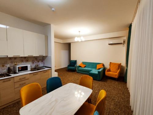 Il comprend une cuisine et un salon avec une table et des chaises. dans l'établissement Vake Park Apartment, à Tbilissi