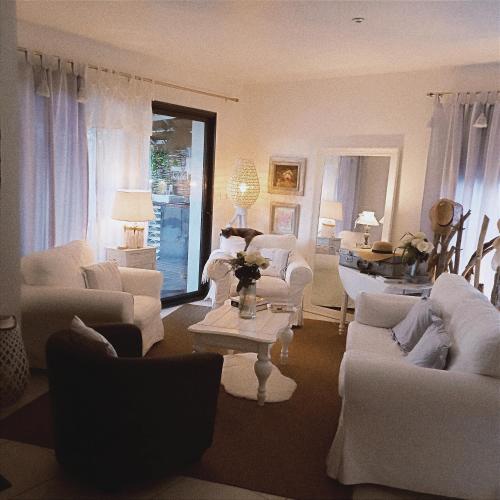 a living room with white couches and a table at Maison neuve et chaleureuse in Morcenx