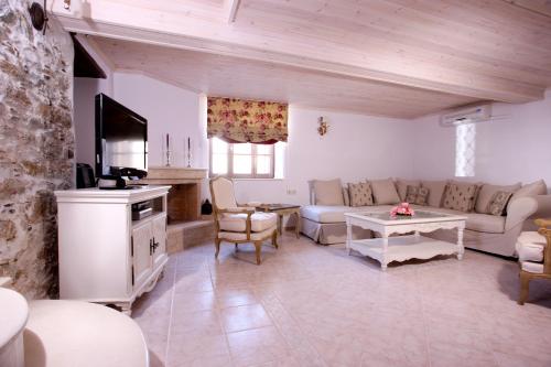 ein Wohnzimmer mit einem Sofa und einem Tisch in der Unterkunft Aegean Diamonds Boutique Villas in Loutráki