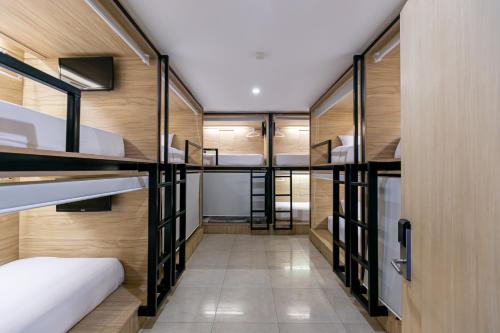 a room with several bunk beds and a hallway at The Bedrooms Hostel Pattaya in Pattaya Central
