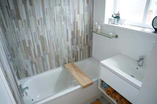 baño blanco con ducha y lavamanos en Sara’s Apartment, en Seaham
