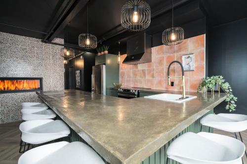 a kitchen with a large counter and white stools at Heaven's Garden / / Luxury penthouse downtown in Quebec City