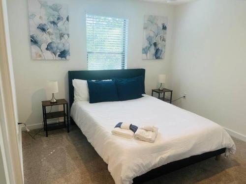 sypialnia z dużym łóżkiem z dwoma ręcznikami w obiekcie Brand New Townhouse, min from Disney w mieście Kissimmee