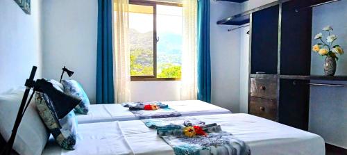 a bedroom with two beds and a window at L’échappée du Cap in Mahe