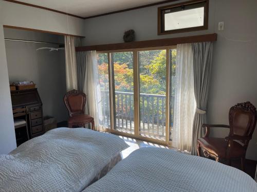 1 dormitorio con cama y ventana grande en 那須リゾートMomiji 貸切, en Nasu