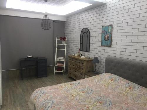 a bedroom with a bed and a brick wall at Stunning Vacation Rental in Matn Lebanon in Dbayeh