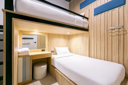 a small bedroom with two bunk beds and a toilet at The Bedrooms Hostel Pattaya in Pattaya Central