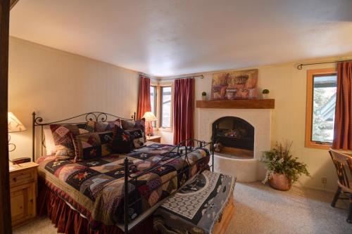 Tamarack Townhomes - CoralTree Residence Collection في سنوماس فيليج: غرفة نوم بسرير ومدفأة