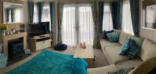 a living room with a couch and a tv at Sunflower Lodge, Lido Leisure Park, Knaresborough in Knaresborough