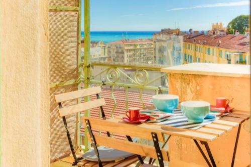 - une table sur un balcon avec vue sur la ville dans l'établissement LE PALAIS DU CHATEAU PORT DE NICE ANTIQUAIRES, à Nice