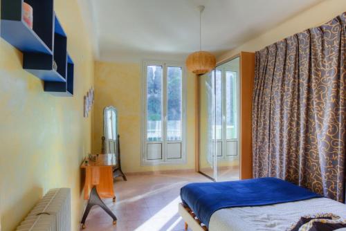 une chambre avec un lit et une grande fenêtre dans l'établissement LE PALAIS DU CHATEAU PORT DE NICE ANTIQUAIRES, à Nice